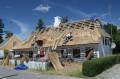Roofers working a traditional reed roof on Aero.